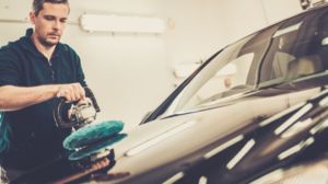 Man on a car wash polishing car with a polish machine