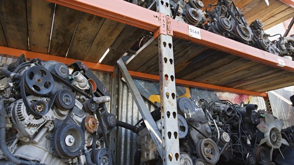 Scraped car engines on shelf in junkyard