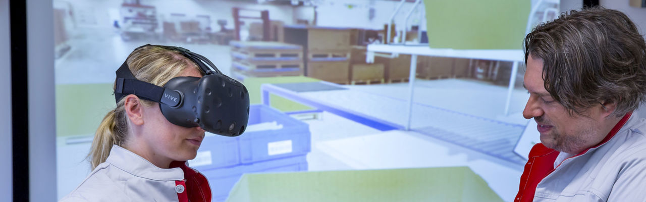 Together with a trainer, an Audi Packing Logistics employee practices the proper techniques for...