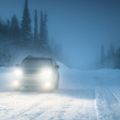 Car lights in winter Russian forest